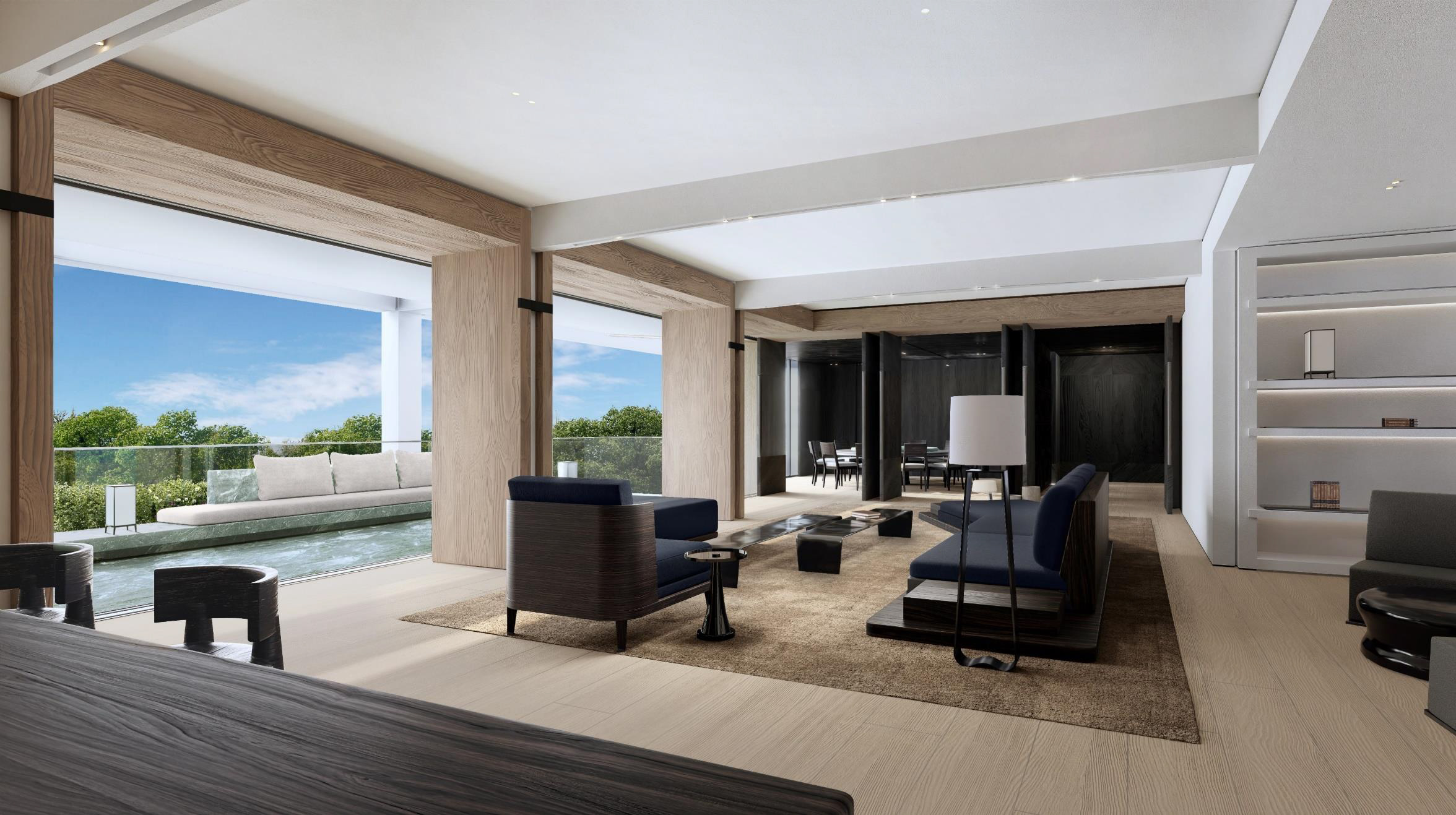 A modern living room with floor-to-ceiling sliding glass doors leading to an outdoor terrace. The room features a neutral color palette, dark blue upholstered furniture, light wood flooring, and recessed lighting. The terrace overlooks a green landscape.