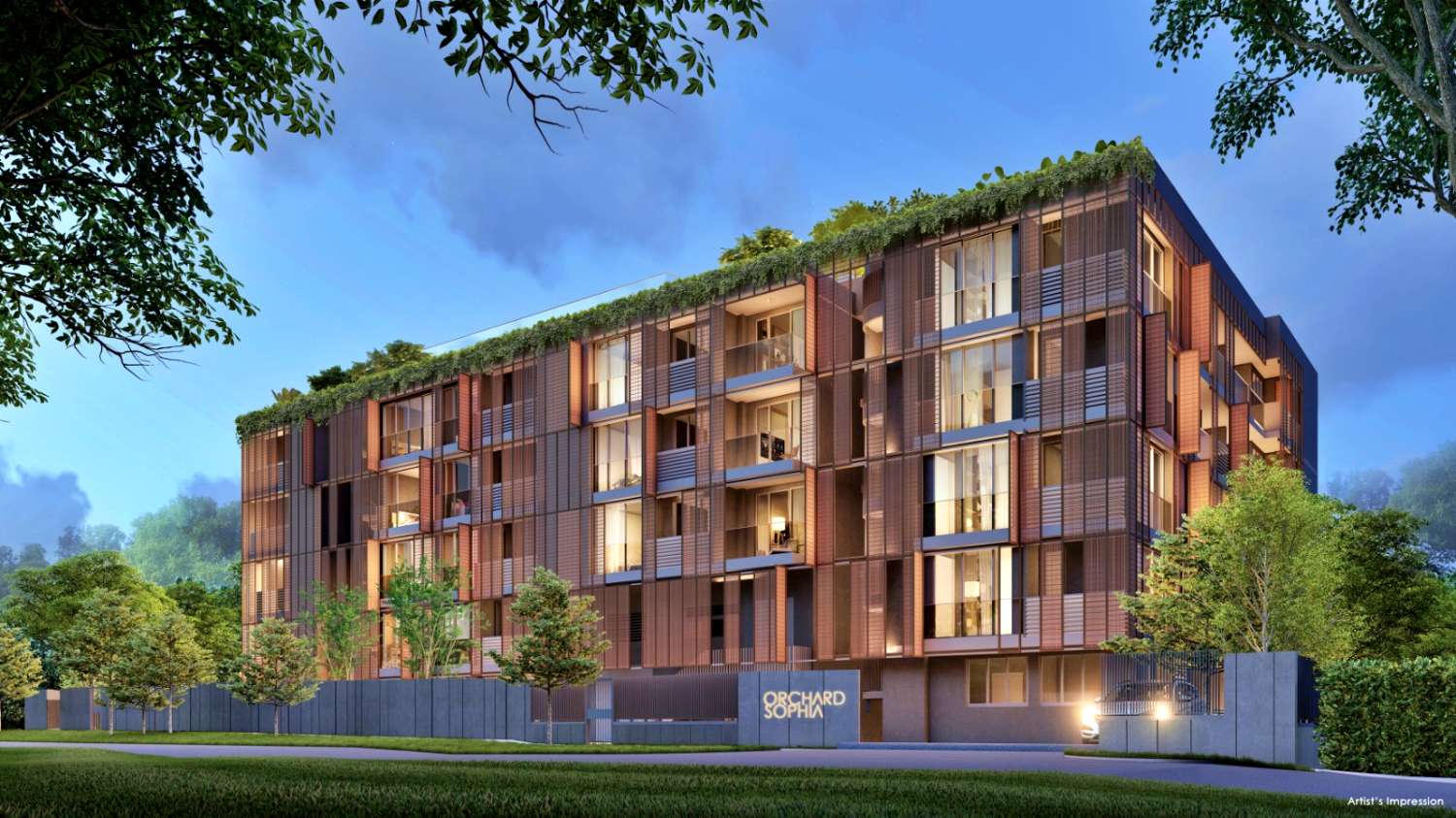 A digital artist's impression of Orchard Sophia, a freehold condominium, in the evening with warm lighting. The mid-rise building features modern architecture with wooden paneling, large glass windows, and greenery on the rooftop. Trees and a well-manicured lawn surround the development, creating a serene atmosphere.