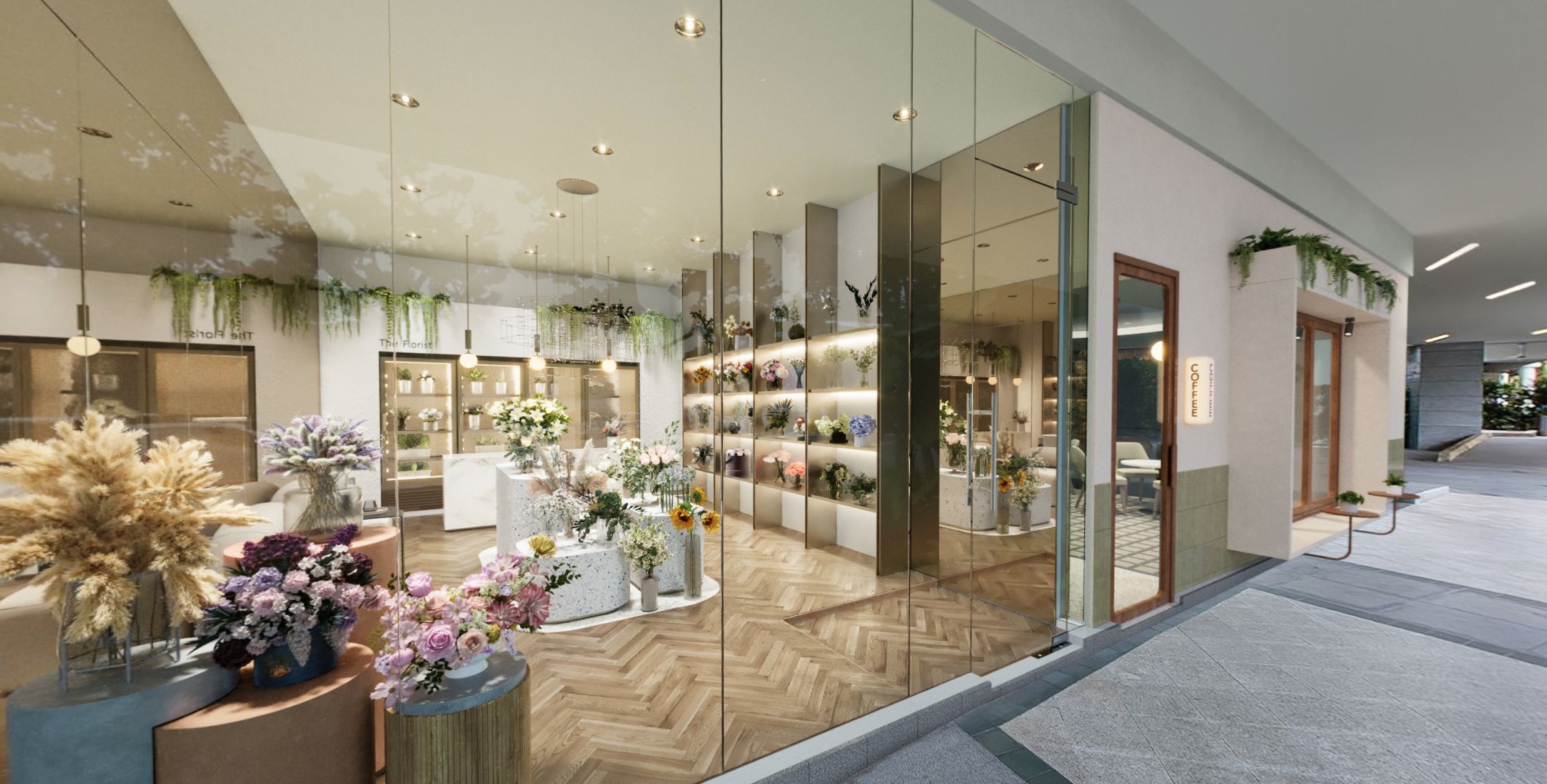 A modern storefront with large glass windows showcasing a flower shop interior. The shop features a variety of floral arrangements, shelves displaying vases and products, and a light-colored herringbone floor. Outside, there's a paved walkway and a glimpse of a residential-style building.