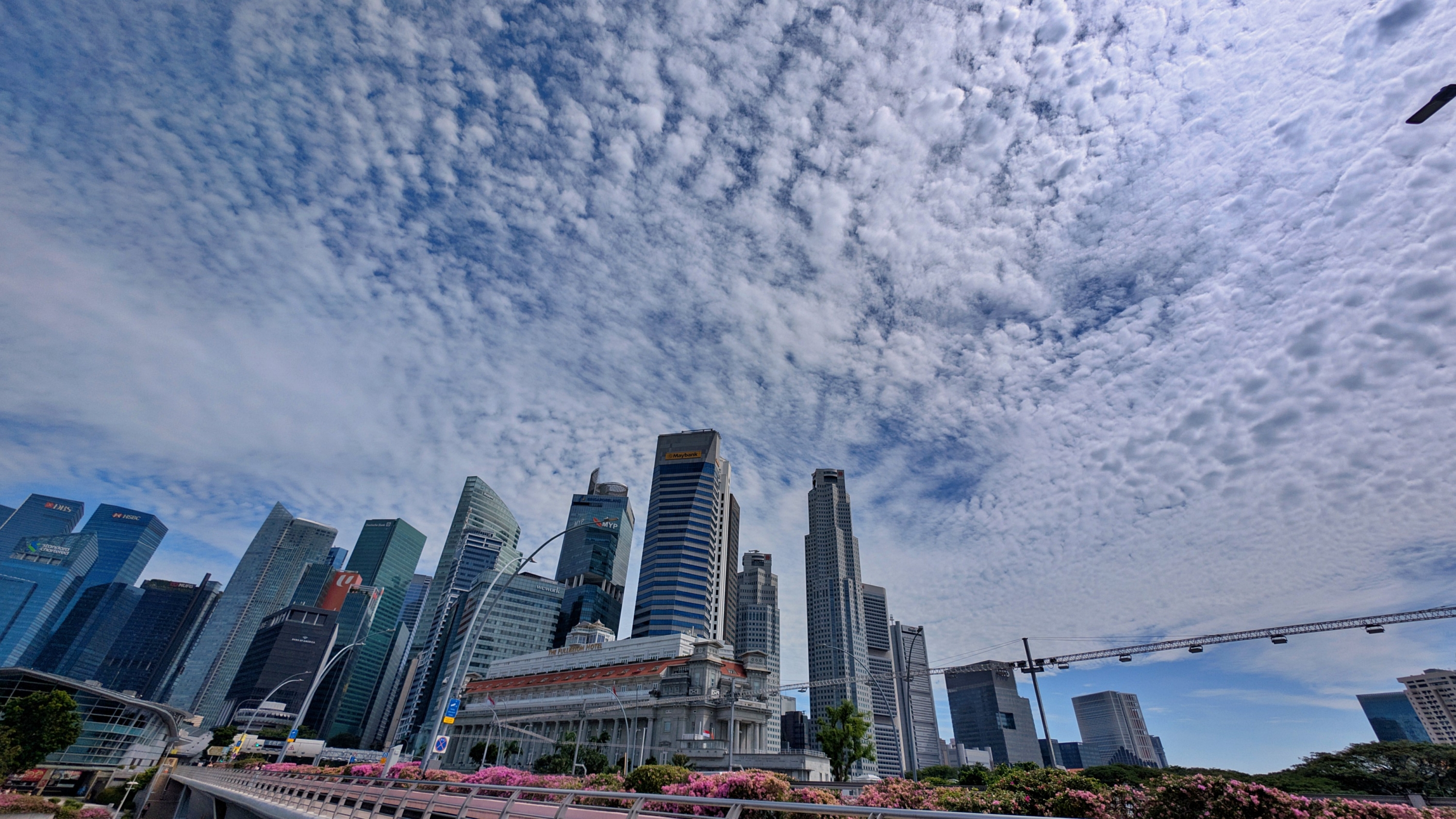 Skyscrapers under a textured cloudy sky in Singapore's CBD.